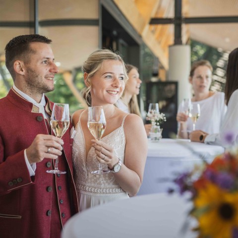 Hochzeitspaar beim Sektempfang auf der Terrasse des Restaurants des ErlebnisQuartier der Talstation der SchafbergBahn in St. Wolfgang am Wolfgangsee.