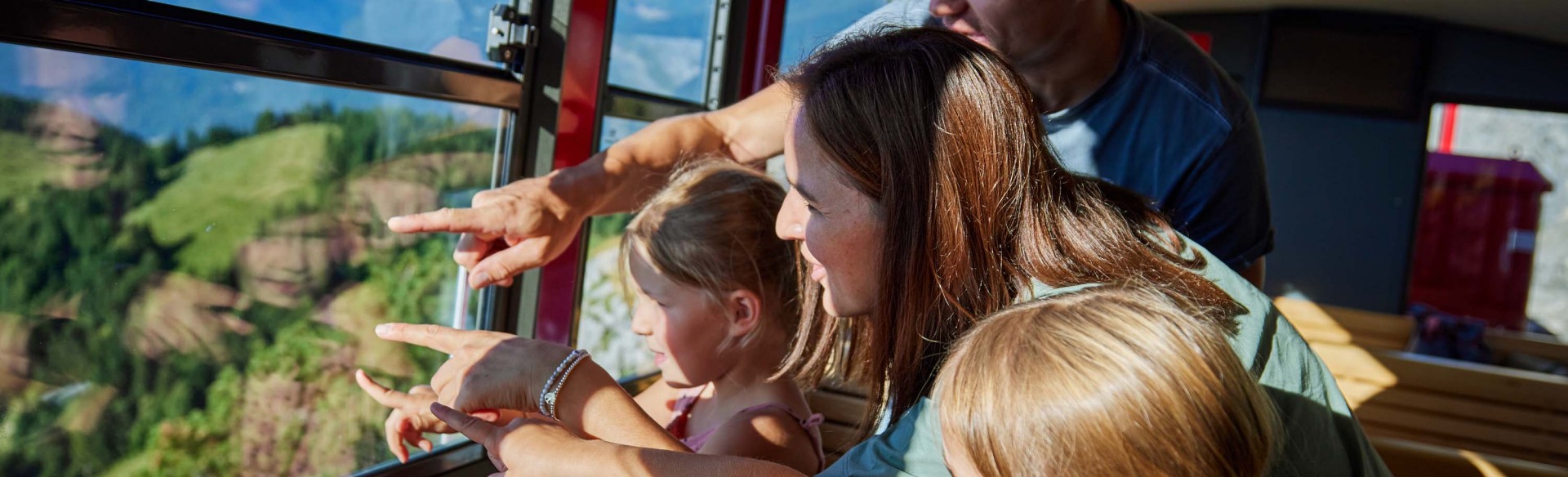 Familie schaut aus dem Fenster der SchafbergBahn in Richtung Tal